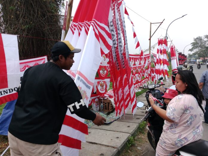 Wawan pedagang bendera di Tigaraksa, Kabupaten Tangerang, sedang menjajakan jualannya, Rabu 5 Agustus 2026. Foto Dani